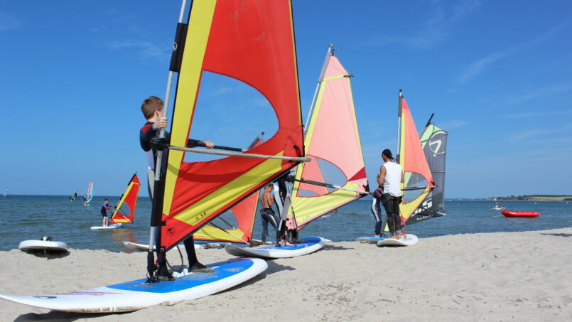 Ein Surflehrer gibt am Strand Surfunterricht